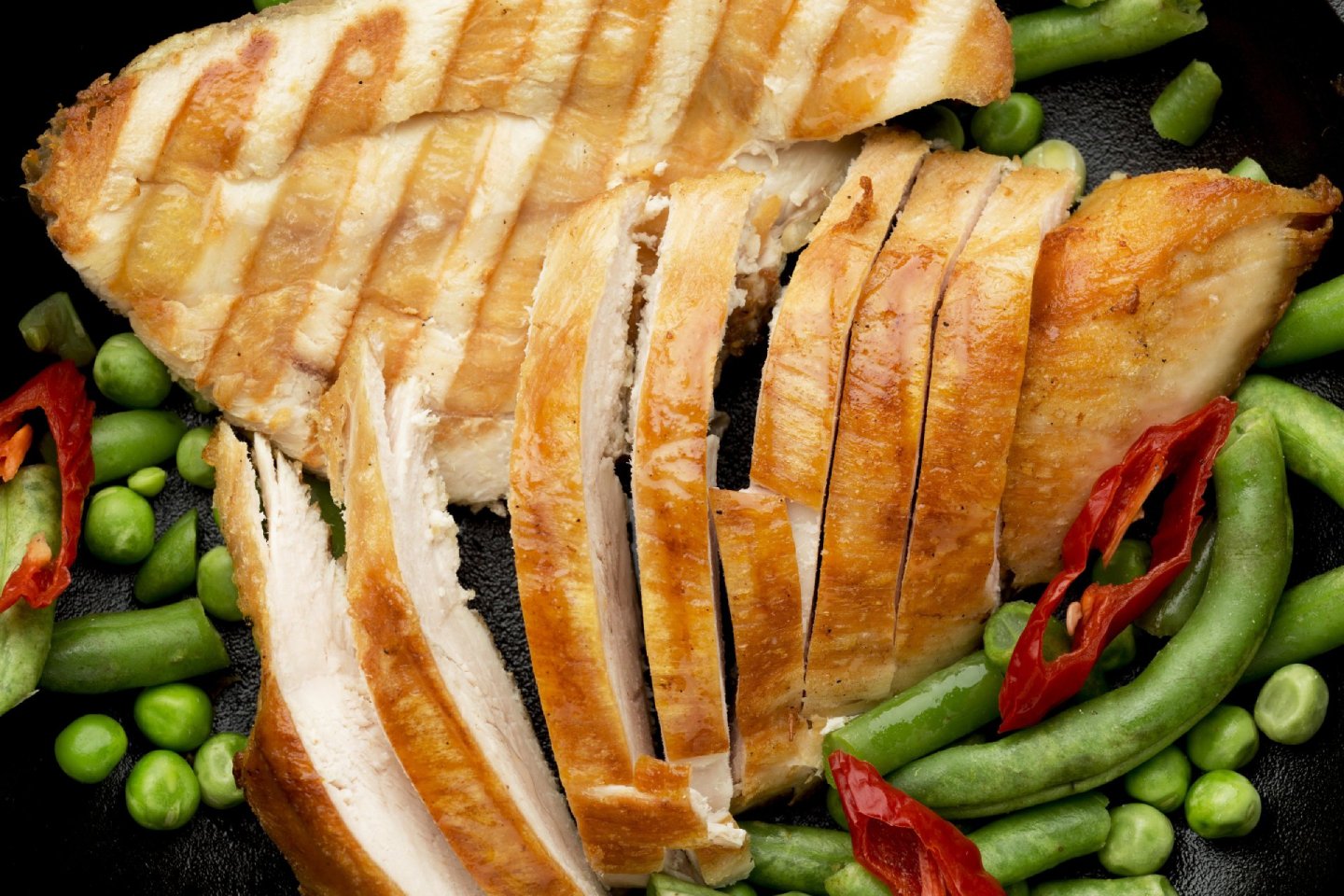 close-up-sliced-grilled-chicken-peas-with-chilli-peppers